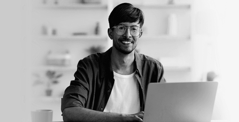 man smiling while working from laptop